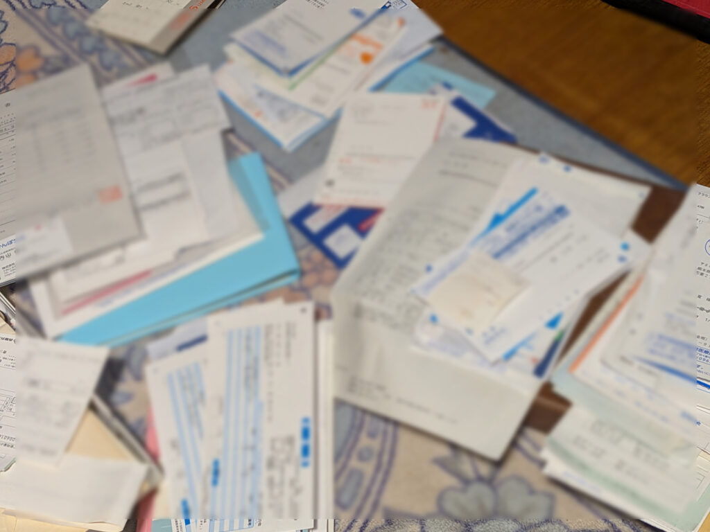 10年以上分の書類を広げて整理している様子(個人情報はぼかし)
